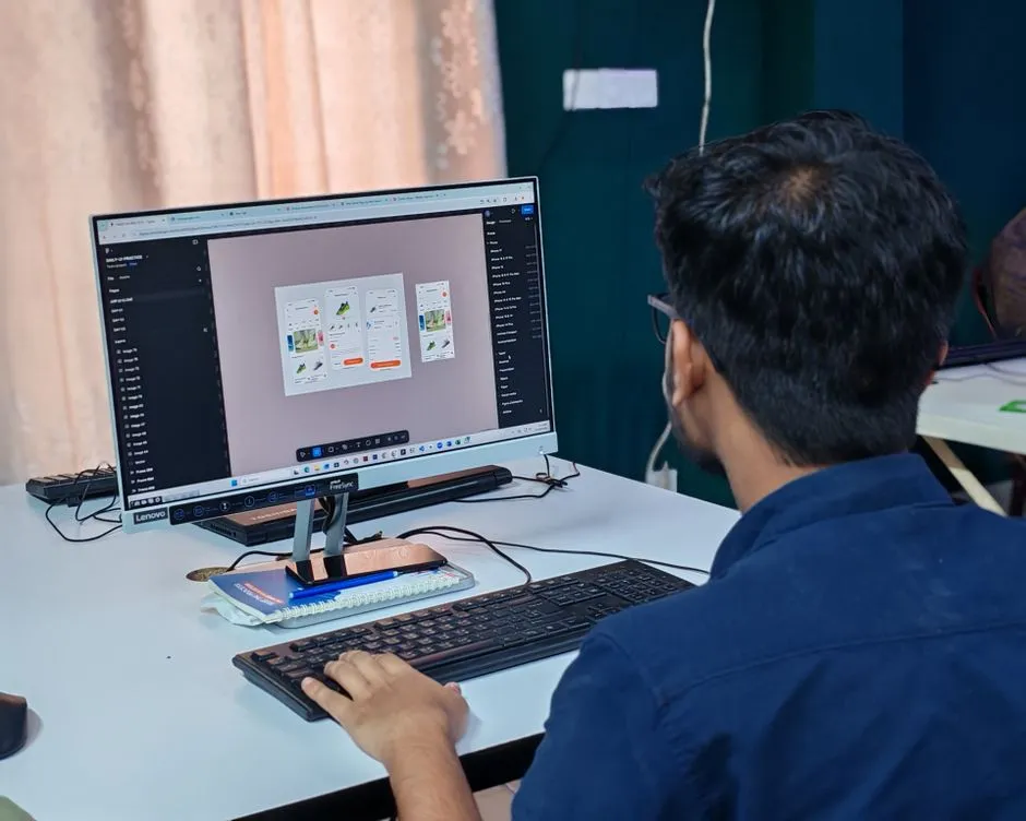 Designer working on user interface icon layouts at a computer workstation